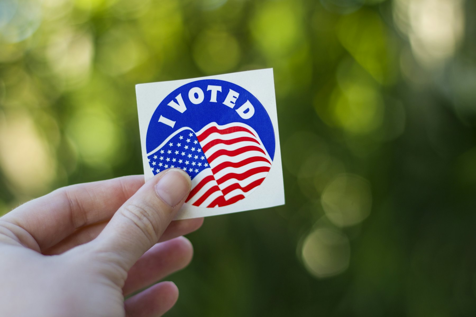 Hand holding an I Voted sticker